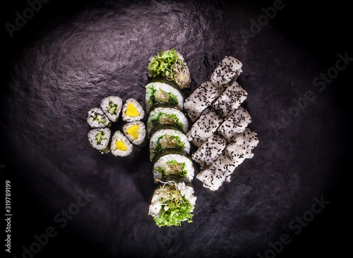 Set of different vegetarian sushi close-up on a dark vintage background.