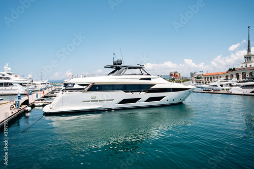 A yacht moored in a dock near beautiful mansions