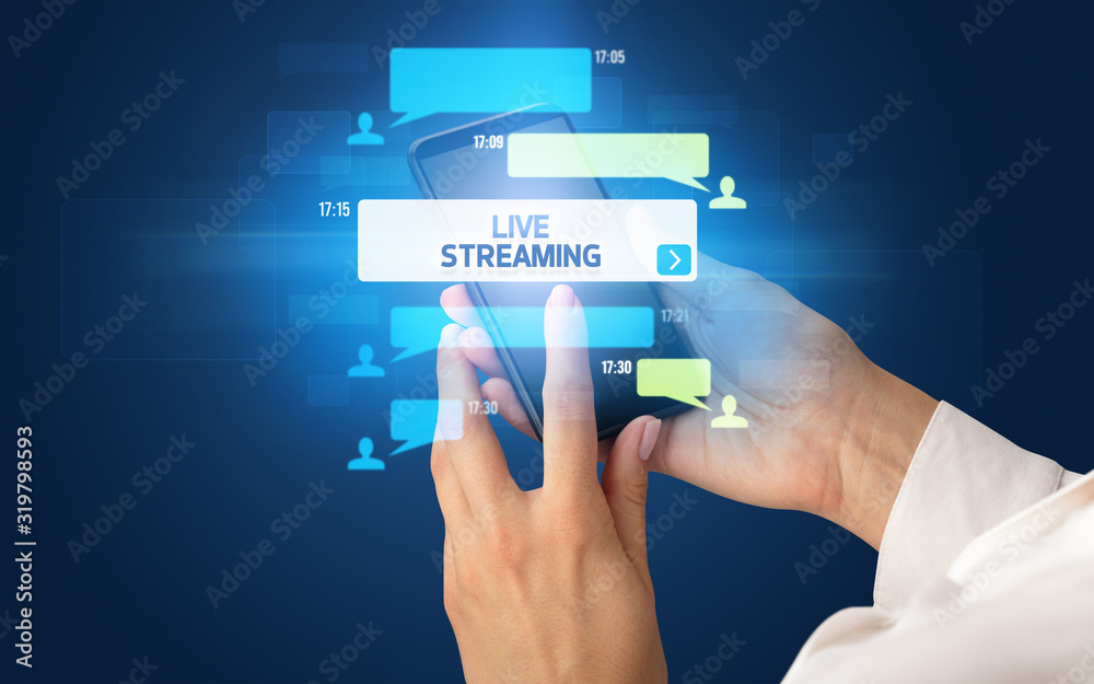 Female hand typing on smartphone with LIVE STREAMING inscription, social networking concept Female hand typing on smartphone with LIVE STREAMING inscription, social networking concept