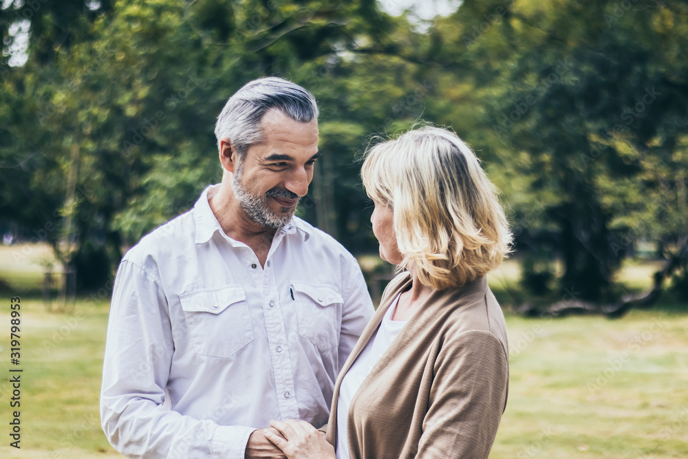 Lovely senior elderly smiling couple man and woman holding hand as promising of forever love or take care in romantic moment. Warm heart marriage and lover bonding and relationship. Love photo concept