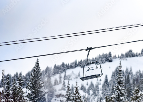 Chair lift above snowy trees at ski resort