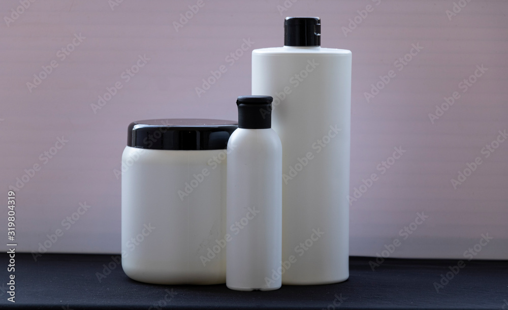 Mockup. White bottles for shampoo and masks for hair or other beauty items. on a black and white background. With a black cover. Red ribbon and heart, and gift. Mockup. White bottles for shampoo and masks for hair or other beauty items. on a black and white background. With a black cover. Red ribbon and heart, and gift.