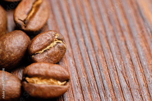 roasted coffee beans on a burnt wooden background. Close up. Copy space.
