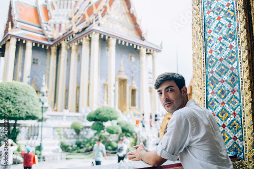 Canvas Print Portrait of handsome spanіsh guy traveler in casual wear standing near ancient a