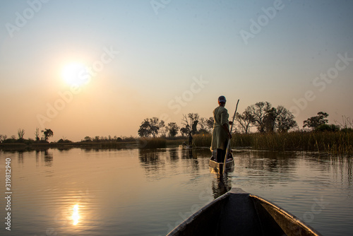 Traditionelle Boote (Mokoros) im Sonnenuntergang im Okavango Delta, Botswana photo