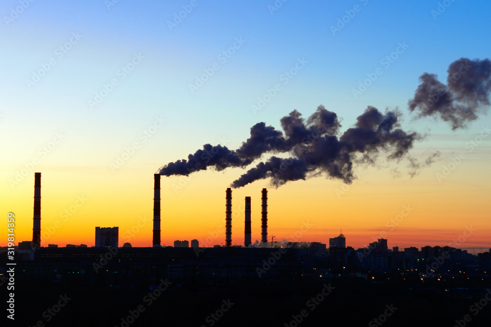 pipes smoke factories at sunset