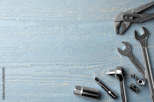 Modern auto mechanic's tools on grey wooden table, flat lay. Space for text photo