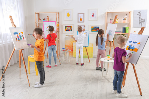 Cute little children painting during lesson in room