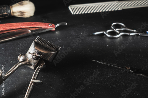 vintage Barber shop equipment on Black background . Professional hairdressing tools. scissor, manual hairclipper, razor, shaving brush, comb photo