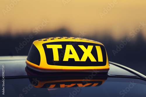 Taxi car with yellow roof sign outdoors, closeup