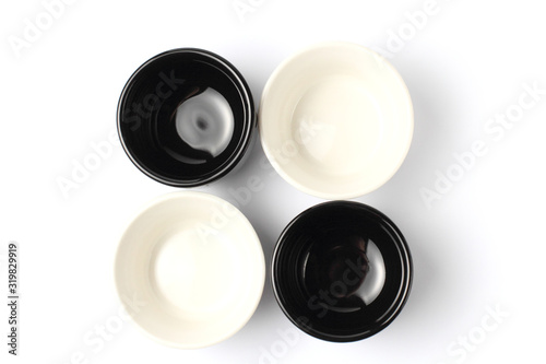 Flat lay, black and white ceramic dishes for sauce on a white background close-up. photo