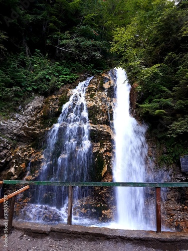 The water of a waterfall that is covered with rocks