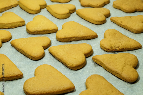 Heart-shaped baked cookies as a Valentine's Day symbol rests on a sheet of grey craft paper