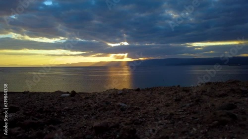 Timelapse, beautiful sunset on the sea, with views of the mountains and rocks in Jordan. Timelapse. Beautiful clouds float quickly against the blue sky
