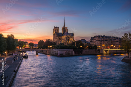 Church of Notre Dame de Paris in France before burning fire at sunset on river Seine reflecting lights