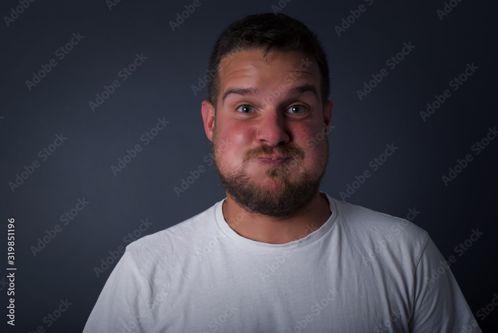 Handsome young man puffing cheeks with funny face. Mouth inflated with air, crazy expression. Handsome young man puffing cheeks with funny face. Mouth inflated with air, crazy expression.