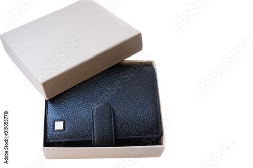 There is an opened gift box with a good, expensive wallet made of black genuine leather lies on the white background. Stylish accessory as a gift for a businessman.