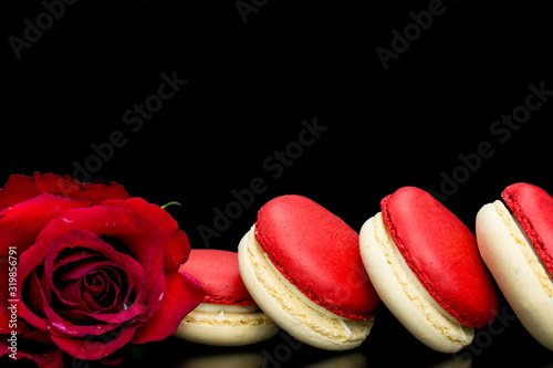 macaroons.red macaroons on black background with red rose for Valentines day photo