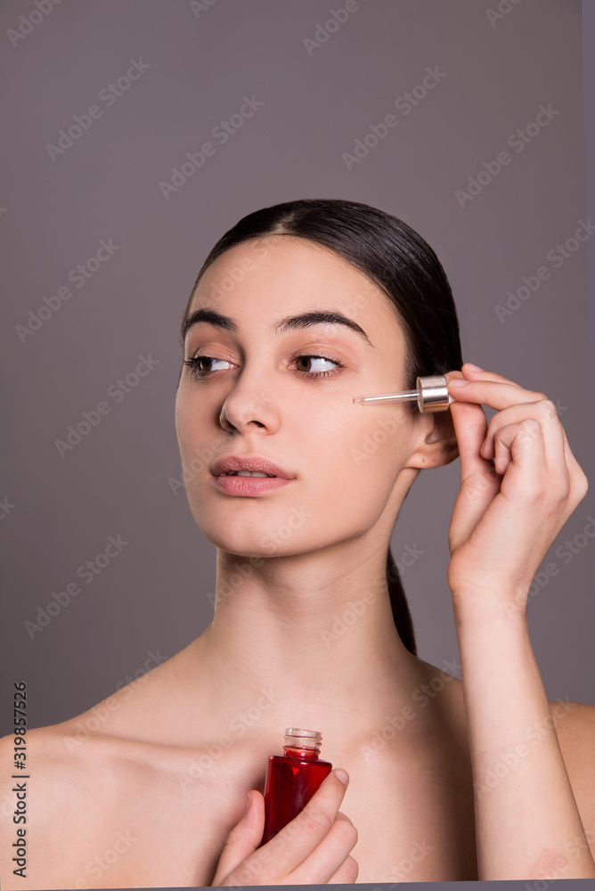 woman portrait close up holding pipette over her face, skin care concept woman portrait close up holding pipette over her face, skin care concept