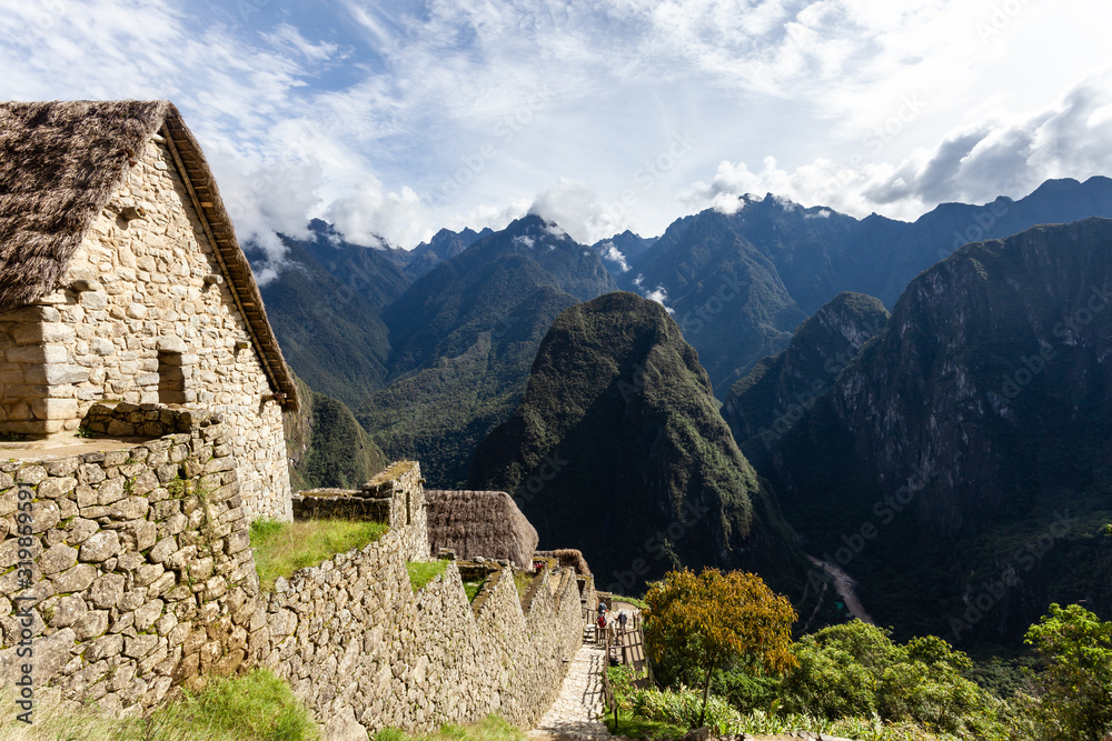 Houses and walls of the city of Machu Picchu, Peru. Clouds and mountains.