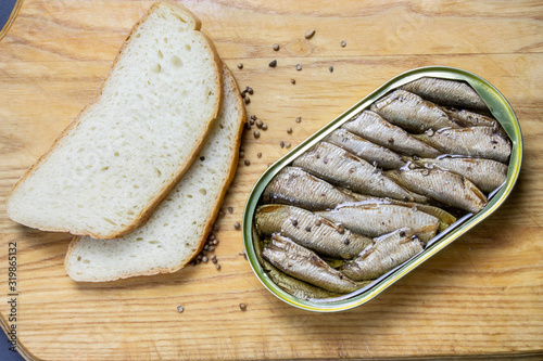 Fotografía Open sprats can and sliced bread with spices on white background close up
