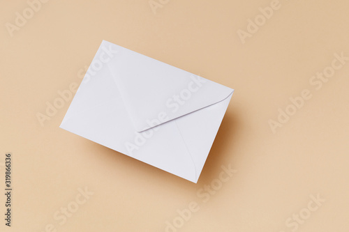 White envelope on the biege background. Mail concept