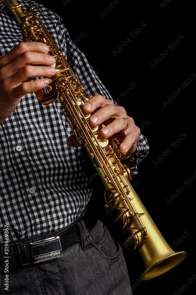 Fototapeta premium soprano saxophone in hands on a black background