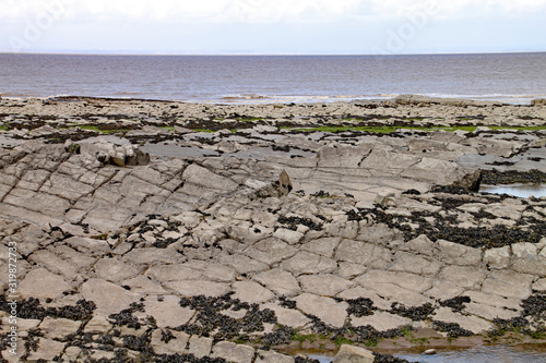 Kilve beach near East Quantoxhead in Somerset, England. Strata of rock dating back to the Jurassic era form huge cracked plateaux along the beach. The area is a paradise for fossil hunters photo