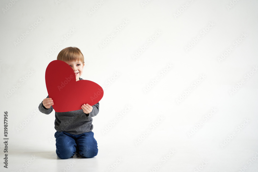 Sweet boy holding red paper heart on white background. Valentines day or kids healthcare, medical concept Sweet boy holding red paper heart on white background. Valentines day or kids healthcare, medical concept