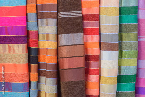 Pieces of fabric and textiles in a factory shop. Multi different colors and patterns on the market.