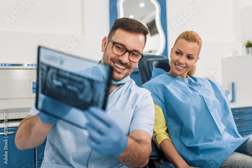 Dentist and patient looking to x-ray
