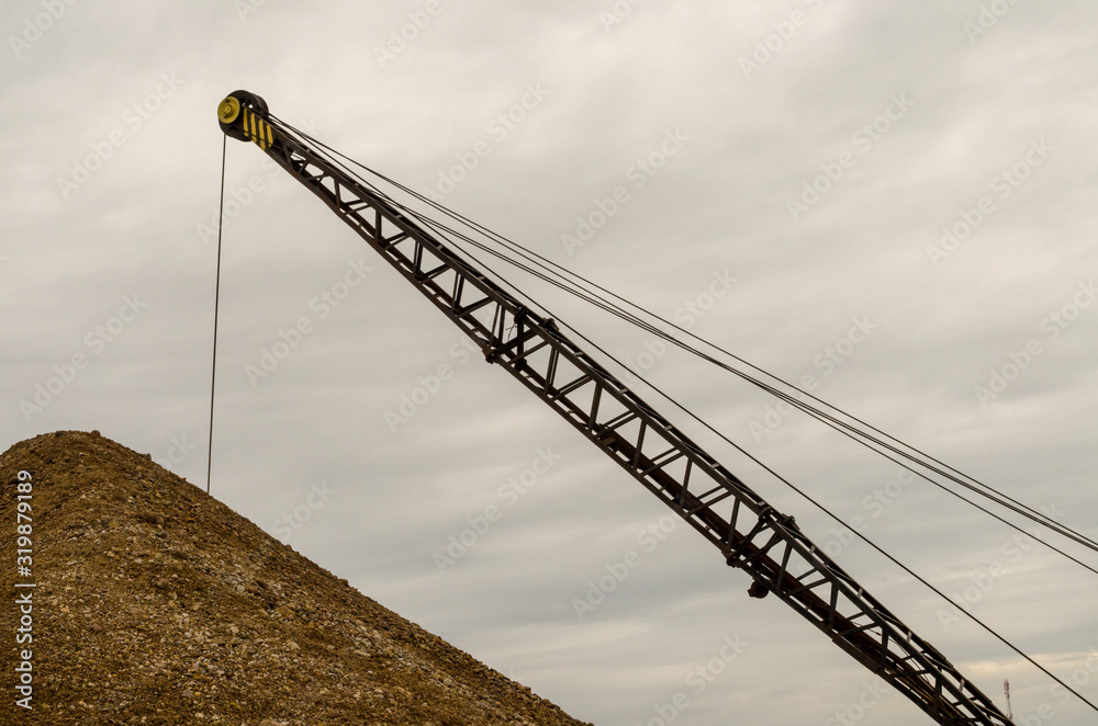 Excavator working in the river gravel quarry against the background of the forest. Extraction of natural resources. Excavator working in the river gravel quarry against the background of the forest. Extraction of natural resources.