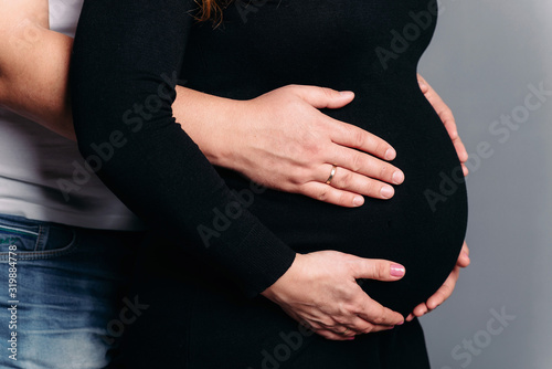 Pregnancy concept, hands of husband and wife on pregnant belly