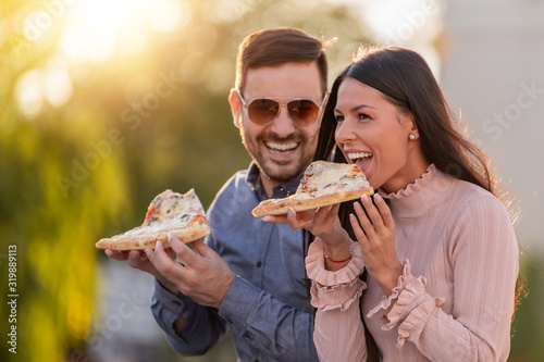 Picture of happy young couple eating pizza