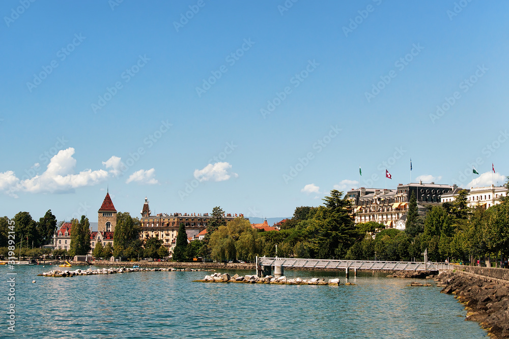 Obraz premium Chateau Ouchy and Lake Geneva promenade in Lausanne, Switzerland. People on the background