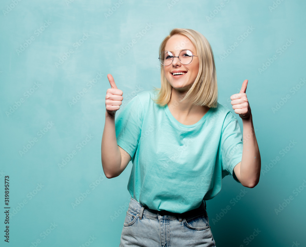 Style blonde woman in glasses show OK gesture on blue background Style blonde woman in glasses show OK gesture on blue background