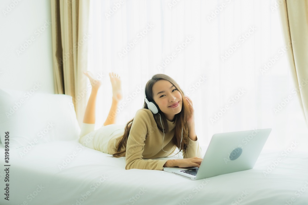 Young asian woman using laptop with headphone for listen music Young asian woman using laptop with headphone for listen music