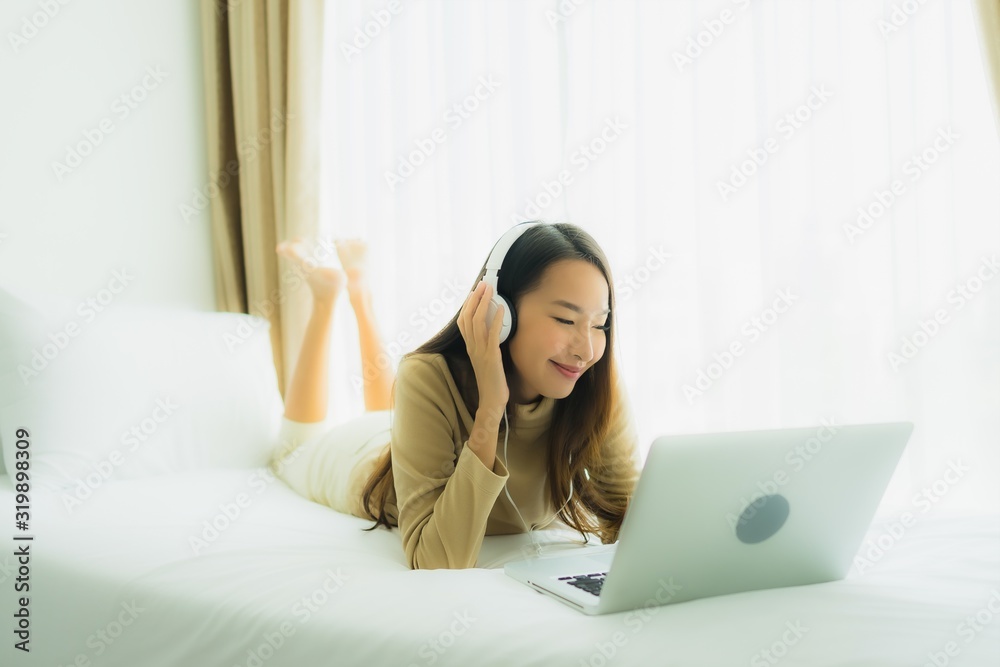 Young asian woman using laptop with headphone for listen music Young asian woman using laptop with headphone for listen music