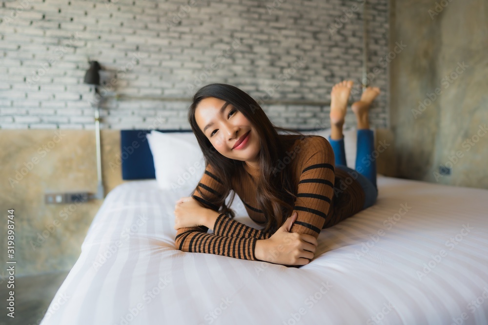 Young asian woman happy smile relax on bed in bedroom