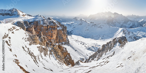 Winter panorama in Dolomites mountains, Italy - view from Pordoi peak (Sass Pordoi) towards an impressive ravine and the tall rock walls lit by the morning light. © k5hu