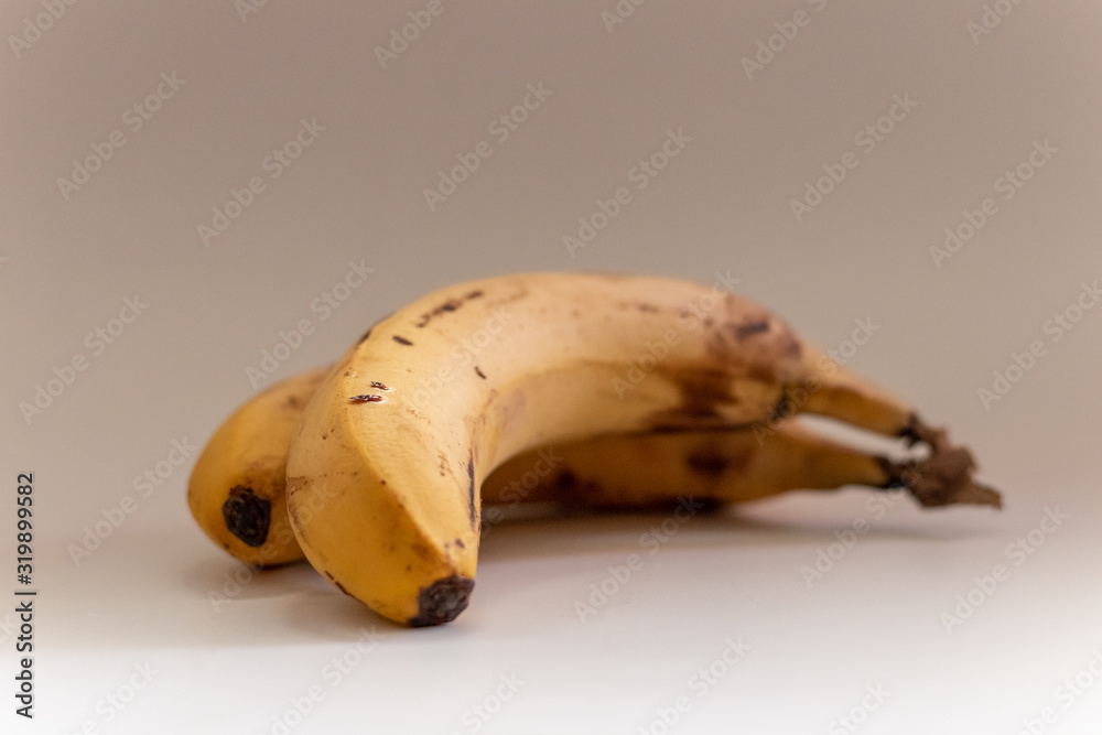 Two tasty and healthy bananas with a grey background Two tasty and healthy bananas with a grey background
