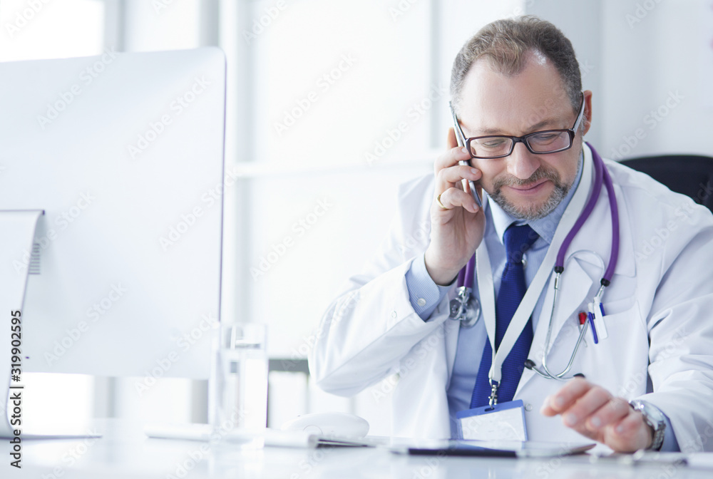 Portrait of senior doctor in office sitting at the desk Portrait of senior doctor in office sitting at the desk