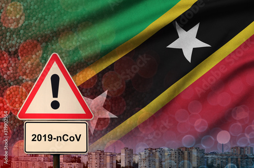 Saint Kitts and Nevis flag and Coronavirus 2019-nCoV alert sign. Concept of high probability of novel coronavirus outbreak through traveling tourists photo