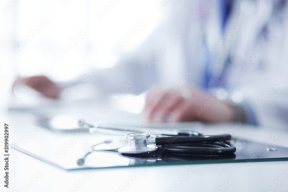 Fototapeta premium Portrait of senior doctor in office sitting at the desk