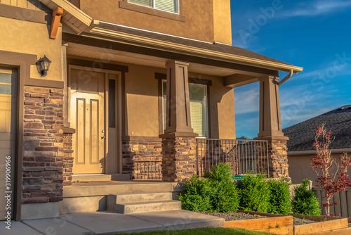 Home with stairs leading to the front door and porch against hill and sky view