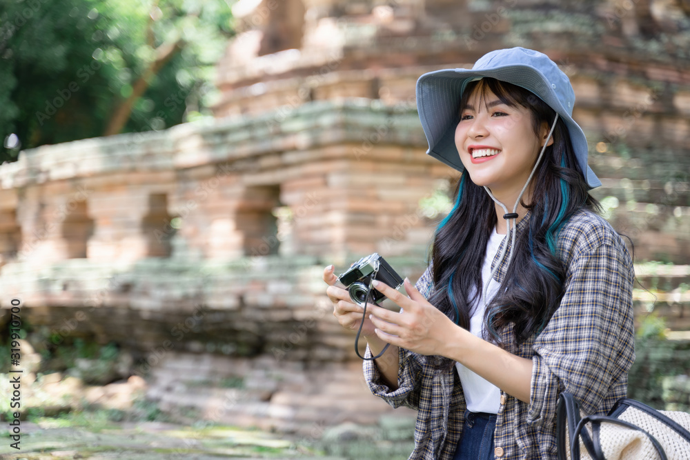 Young woman traveler traveling in old temple. Asian tourist concept