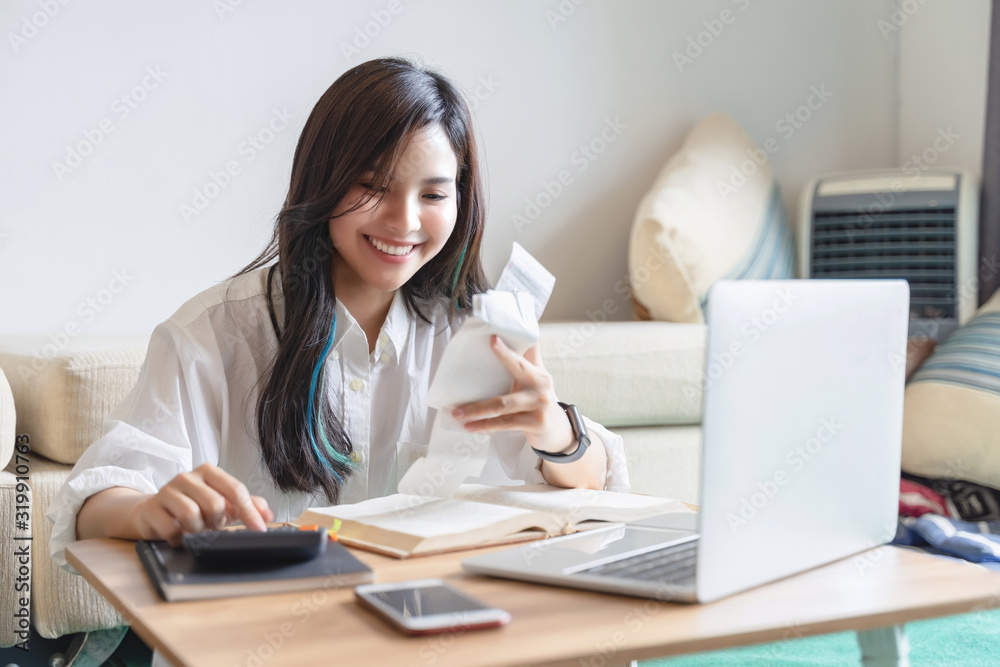 Asian female accountant analyze and discuss the situation on the financial report in living room. working at home concept Asian female accountant analyze and discuss the situation on the financial report in living room. working at home concept