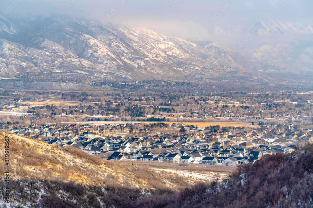 Scenic residential landscape amid stunning snowy mountain on a sunny winter day