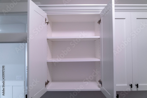 Hanging wall cabinets with open doors and shelves at a new home interior