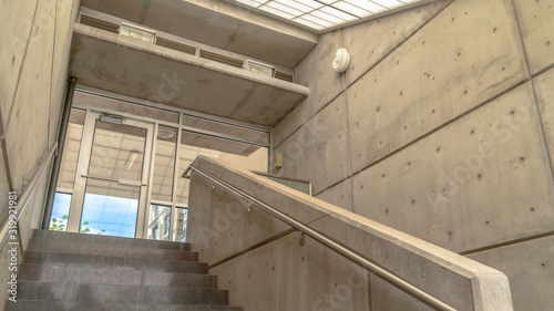 Panorama frame Concrete stairs with side walls and handrails under sloping slant glass roof